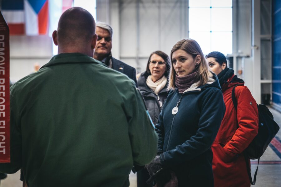 Hanna Steinmueller einem Mann in Uniform zuhörend.