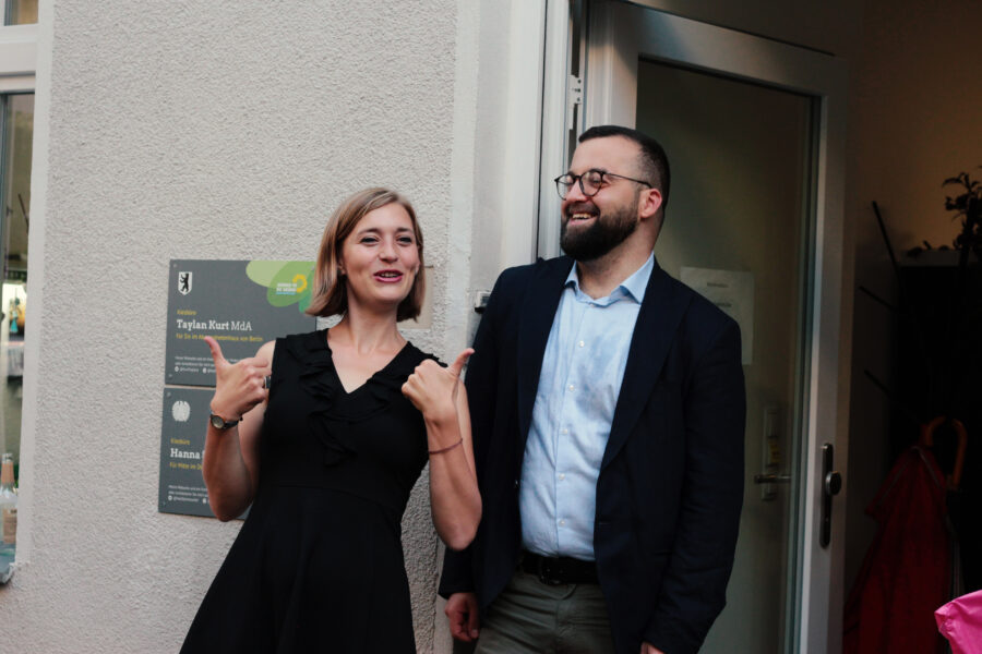 Hanna Steinmüller MdB und Taylan Kurt MdA vor ihrem gemeinsamen Kiezbüro in Moabit. Beide lachen.